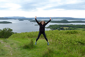 A person jumping over looking Loch Lomond