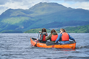 Three people on a guided canoe tour on Loch Lomond